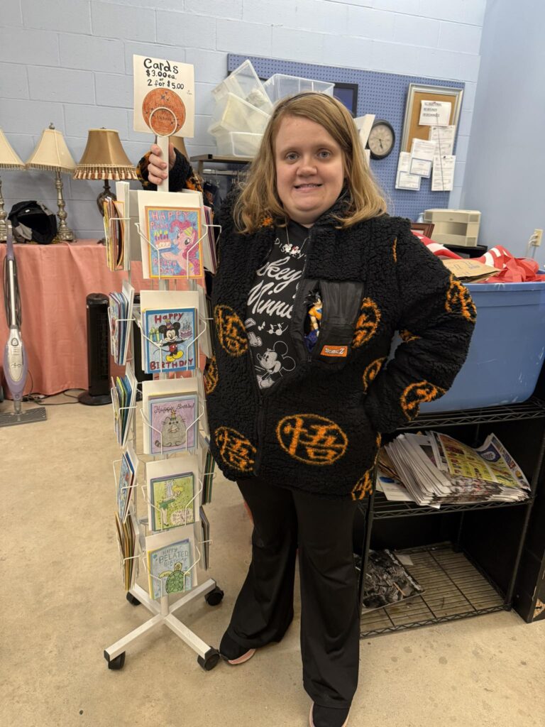 Victoria poses with her handmade greeting cards, for sale at Allied Attic's Thrift Shop